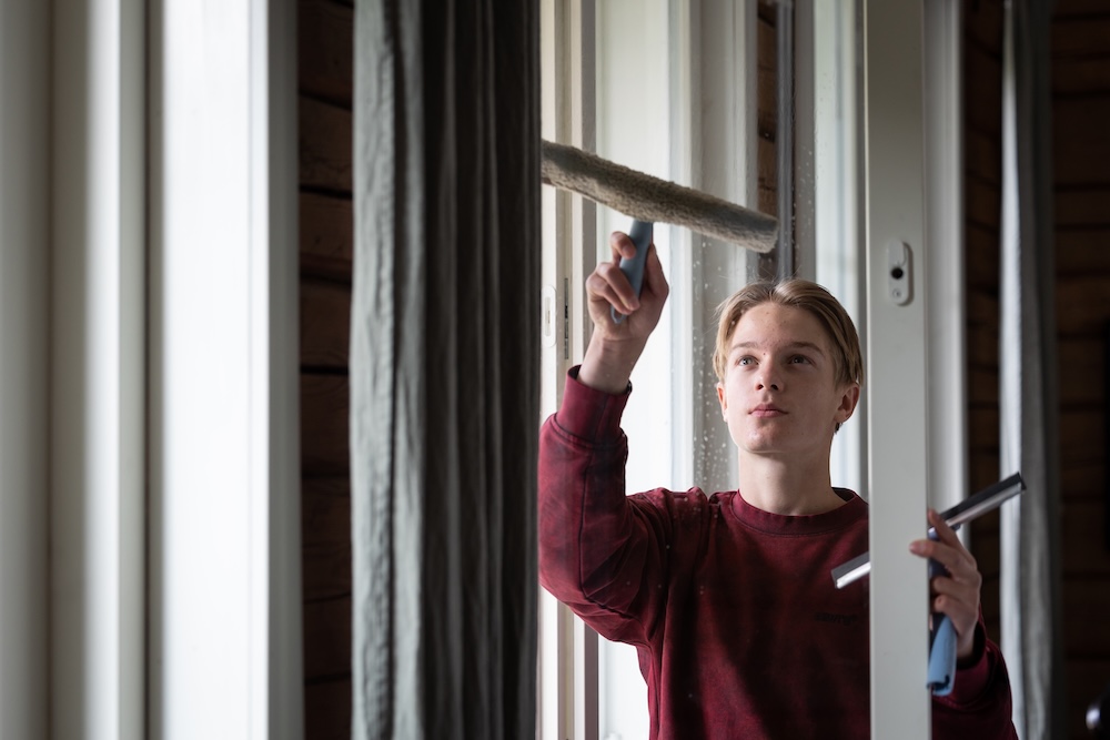 Nuori mies pesee ikkunaa, kuva: Emmi Virta